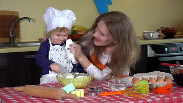 cute daughter with mother put flour on nose. Playful family girls in kitchen - Footage, Video