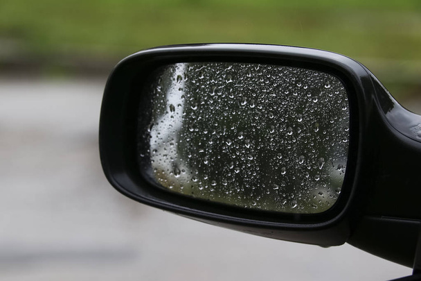 coche de conducción en la lluvia - gotas de lluvia en el espejo retrovisor lateral en días lluviosos
 - Foto, imagen