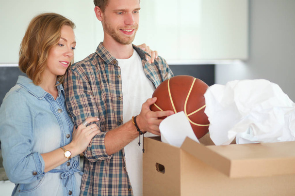 Couple unpacking cardboard boxes in their new home. Young couple. - 写真・画像