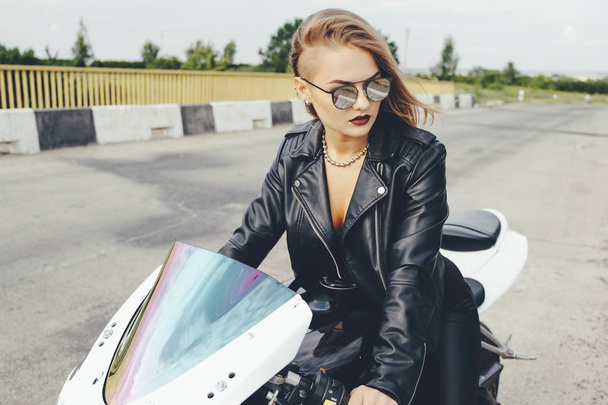 Motorcu kız bir motosiklet üzerinde bir deri giysili - Fotoğraf, Görsel
