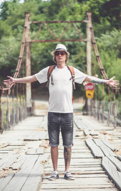 Hiker is crossing wooden bridge in Georgia - Foto, Imagen