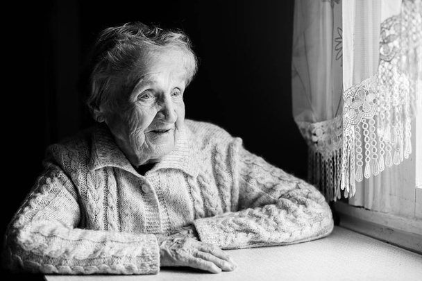 Літня жінка сидить за столом
  - Фото, зображення