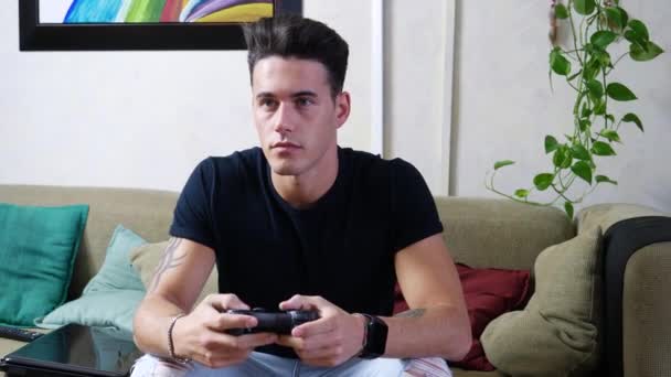 Young man using joystick or joypad for videogames - Materiał filmowy, wideo