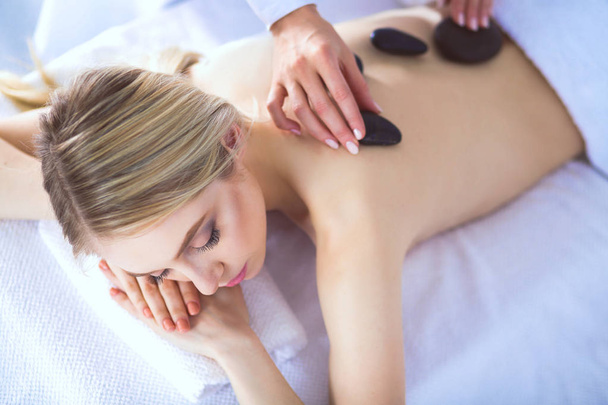 Young woman lying on a massage table,relaxing with eyes closed. Woman. Spa salon - Foto, afbeelding