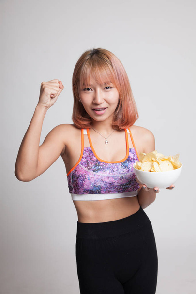 Beautiful Asian healthy girl  eat potato chips. - Foto, imagen
