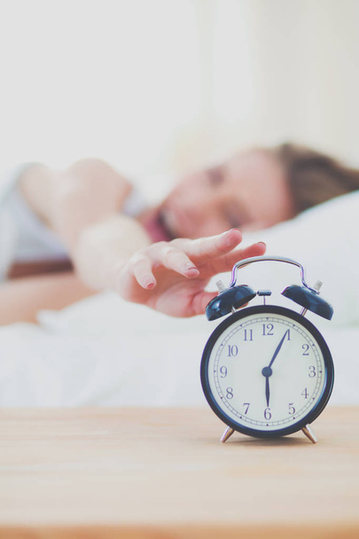 Young sleeping woman and alarm clock in bedroom at home. Young sleeping woman. - Photo, image