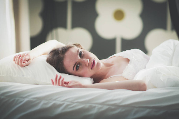 Όμορφη γυναίκα ξαπλωμένη στο κρεβάτι της στο σπίτι. - Φωτογραφία, εικόνα
