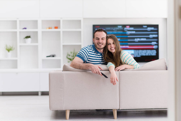Young couple on the sofa watching television - Foto, imagen