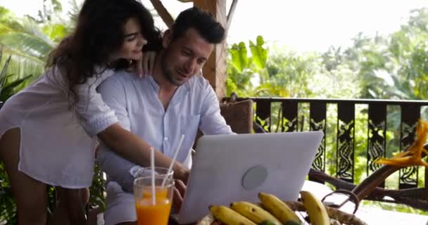 Young Couple Use Laptop Coputer Together On Terrace In Summer Forest, Beautiful Man And Woman Surfing Internet Talking - Felvétel, videó