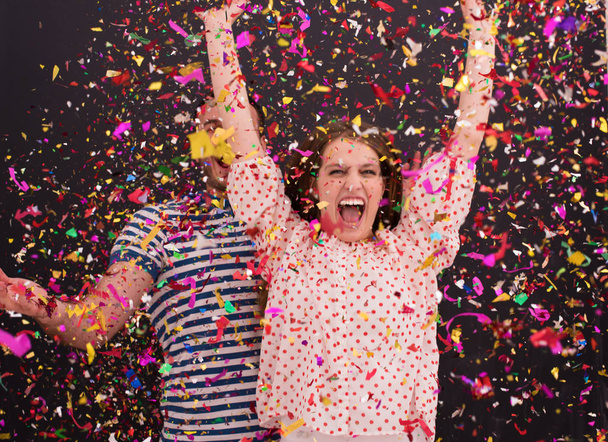 couple blowing confetti in the air isolated over gray - Photo, Image
