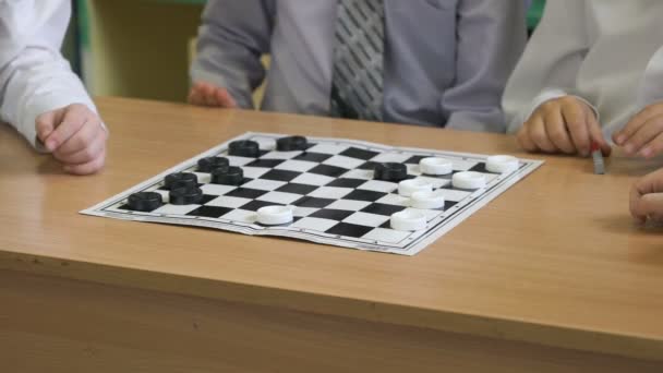 The children play checkers in kindergarten indoors - Filmati, video