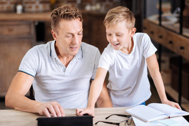 Pre-teen boy explaining father how to use tablet - Foto, Imagen