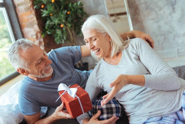 Positive elderly man giving a present to his wife - Valokuva, kuva