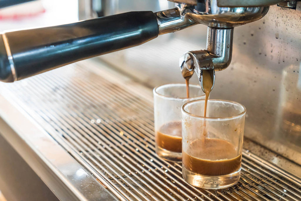 Professionele koffiezetapparaat die espresso maakt in een café - Foto, afbeelding