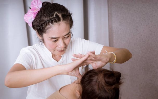 Terapeuta de massagem tailandesa está dando massagem no pescoço para uma mulher
 - Foto, Imagem