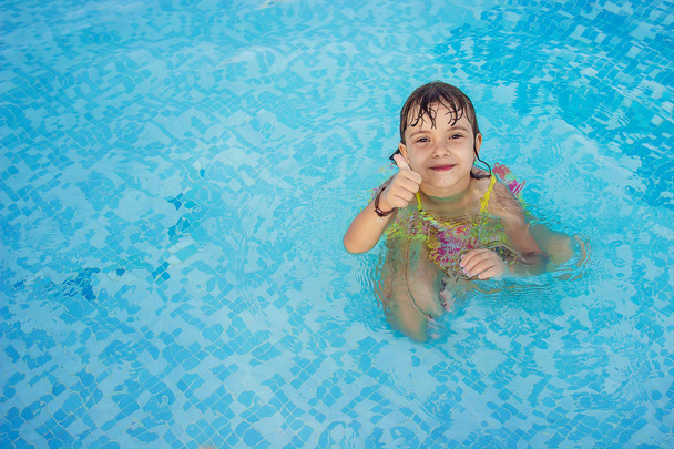 Das Kind badet im Pool des Resorts. Selektiver Fokus.  - Foto, Bild