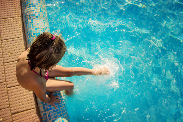 The child is bathing in the pool at the resort. Selective focus.  - Photo, Image