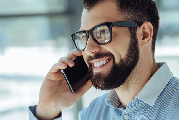 Close up of happy bearded man talking on phone - Фото, изображение