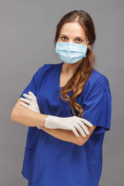 Kadın doktor mavi üniforma ve yüzünde maske - Fotoğraf, Görsel