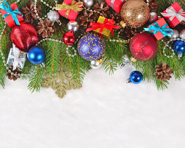 Christmas decorations on a spruce branch on a white - Fotó, kép