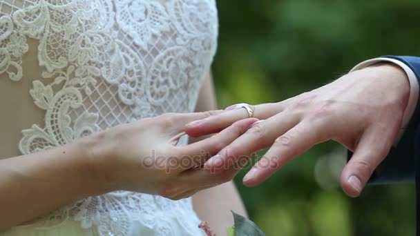 The groom places the ring on the bride's hand. - Footage, Video