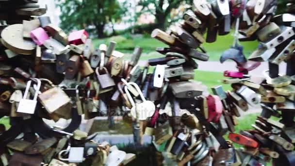 Many locks are attached to metal fence in summer city park. - Footage, Video