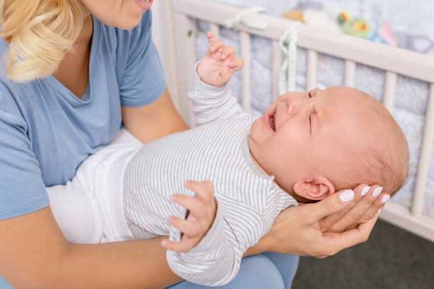 mother holding crying baby - Zdjęcie, obraz