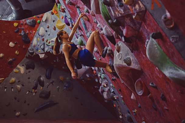 Vrouwelijke klimmer. Extreme indoor klimmen. - Foto, afbeelding