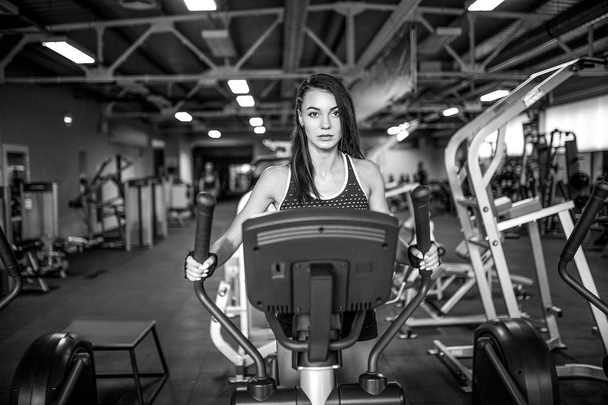 Young fitness woman doing cardio exercises at the gym running on a treadmill. - 写真・画像