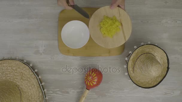Puts food in the dish with a knife. On the table is the two Mexican hats, maracas, abstraction for instagram - Footage, Video