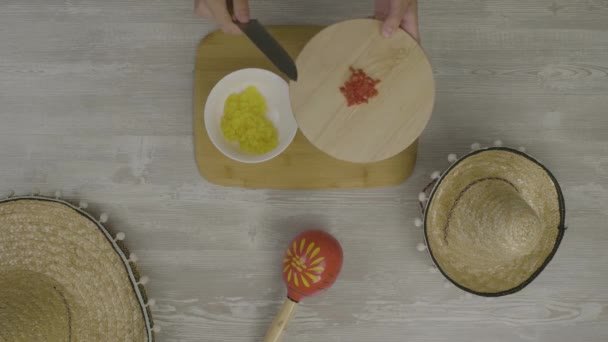 Coloca comida no prato com uma faca. Na mesa estão os dois chapéus mexicanos, maracas, abstração para instagram
 - Filmagem, Vídeo