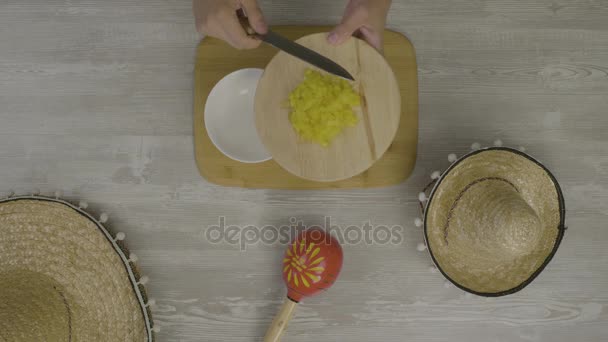 Puts food in the dish with a knife. On the table is the two Mexican hats, maracas, abstraction for instagram - Footage, Video