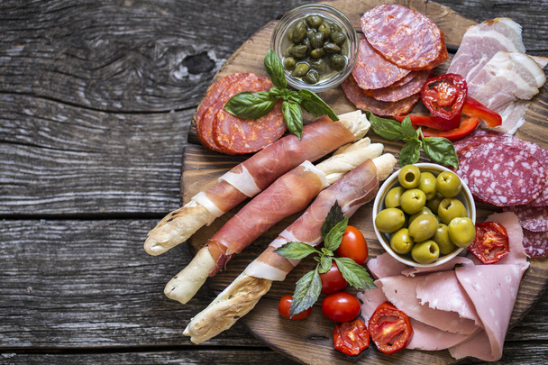 Italian food, prosciutto, grissini, smoked sausage, ham, olives, - Фото, изображение
