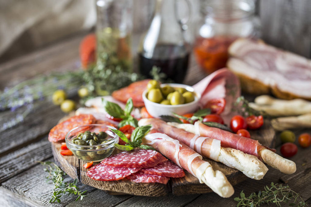 Italian food, prosciutto, grissini, smoked sausage, ham, olives, - Foto, imagen