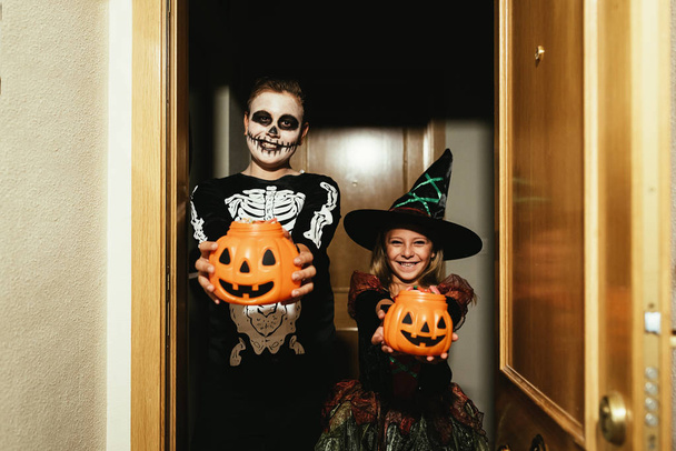 Happy children disguised saying trick or treating. - Fotó, kép