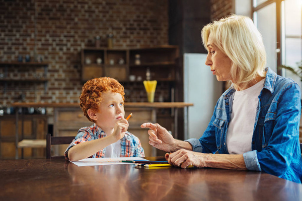 Smart little boy listening to grandmother attentively - Photo, Image