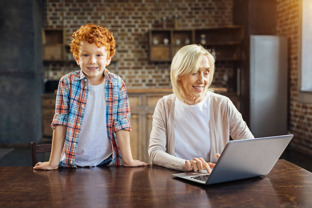 Excited kid joining his grandmother working on laptop - Foto, Imagem