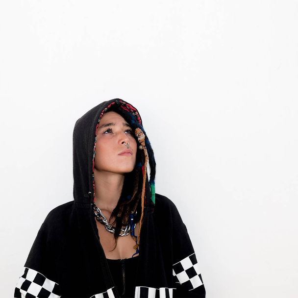 Latin teen with dreadlocks and piercings. In a black hoodie. Str - Foto, Bild