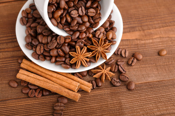 Coffee beans and cinnamon on a background of burlap. Roasted coffee beans background close up. Coffee beans pile from top with copy space for text. Seasoning. Spice. Cinnamon. Badian. Coffee house. - Fotó, kép