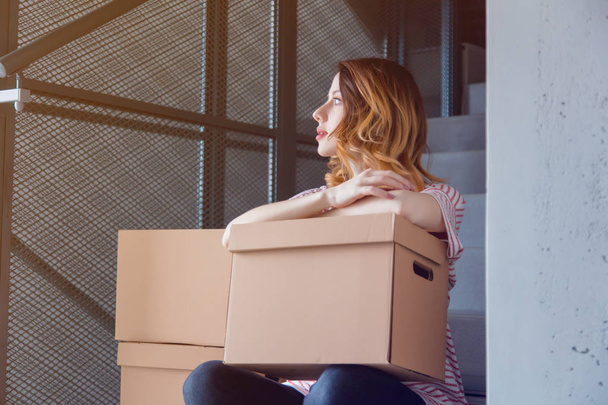 woman sitting with cardboard moving box - Foto, Imagen