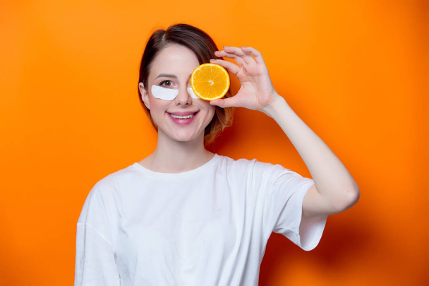 Mujer sosteniendo rebanada naranja
 - Foto, imagen