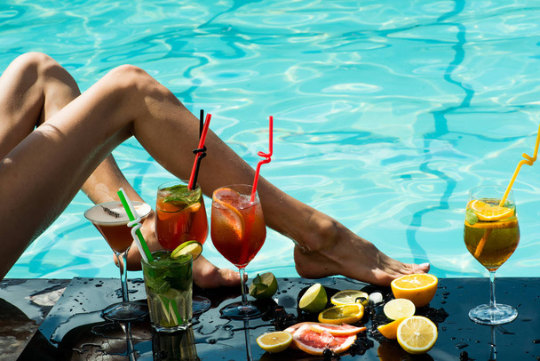 Cocktail and sexy leg of girl in pool. - Photo, image