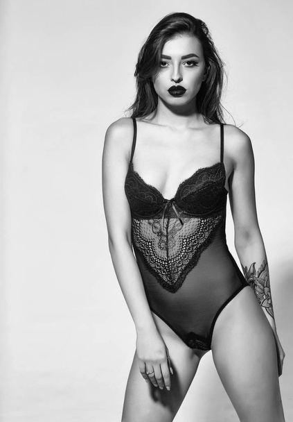 sexy woman with red lips in black bodysuit has tattoo - Photo, image