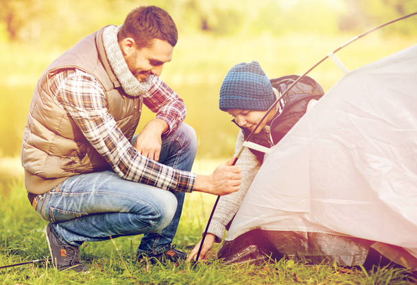happy father and son setting up tent outdoors - Foto, Imagem
