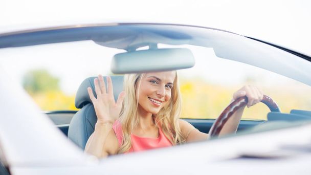Gelukkig jonge vrouw rijden converteerbare auto - Foto, afbeelding