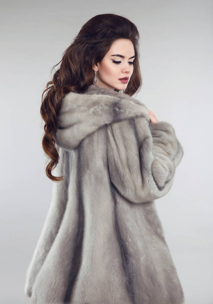 Mulher na moda em casaco de pele de vison sobre estúdio fundo cinza
.  - Foto, Imagem