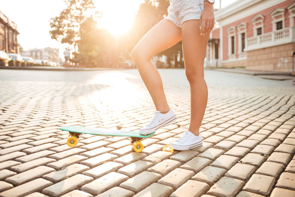 Cropped picture of young woman with skateboard - Foto, afbeelding
