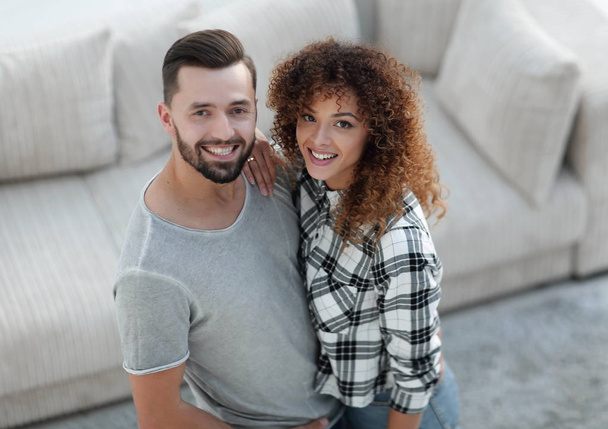 young couple standing in new living room and looking at camera - Foto, imagen