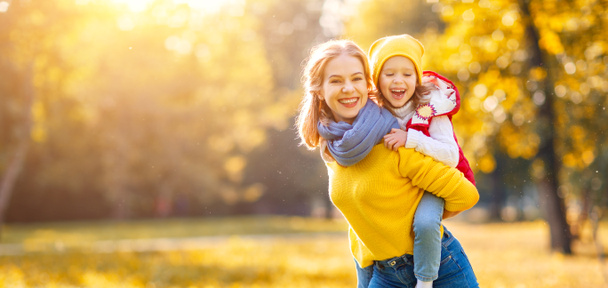秋の散歩に、幸せな家族母と子の娘  - 写真・画像