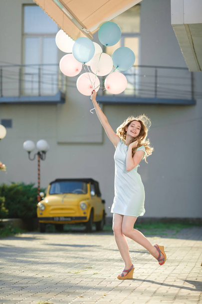 beautiful woman with flying multicolored balloons - Fotó, kép